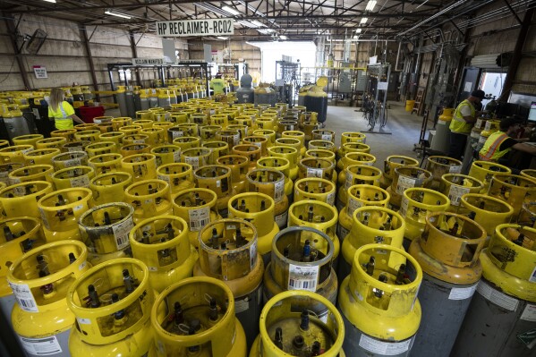 Used refrigerant cylinders sit in a warehouse at the A-Gas Rhome facility on Monday, Oct. 9, 2023, in Rhome, Texas. The company takes in shipments of refrigerators and tanks from around the country and beyond, drains them, then purifies and reclaims the chemicals, shipping out recycled product. This prevents the need for new chemical production. (AP Photo/Sam Hodde)