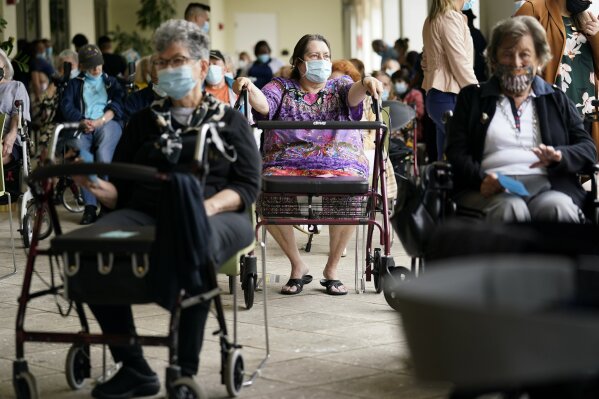 FILE - In this Jan. 12, 2021, file photo Resident Sabeth Ramirez, 80, center, waits in line with others for the Pfizer-BioNTech COVID-19 vaccine at the The Palace assisted living facility in Coral Gables, Fla. An ongoing study suggests that older American adults are showing resilience and perseverance despite struggles with loneliness and isolation during the pandemic. (AP Photo/Lynne Sladky, File)