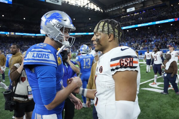 Detroit Lions quarterback Jared Goff, left, and Chicago Bears quarterback Justin Fields meet after the second half of an NFL football game, Sunday, Nov. 19, 2023, in Detroit. (AP Photo/Paul Sancya)