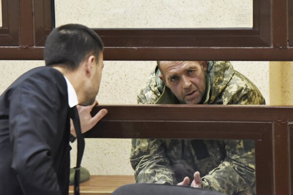 
              One of the captured Ukrainian sailors speaks with his lawyer in a court room in Simferopol, Crimea, Tuesday, Nov. 27, 2018. A Crimean court has ordered one of the Ukrainian seamen captured by Russia at the weekend held in custody for the next two months. The seamen and their vessels were captured by Russian border guards late on Sunday as they were about to make their way through the Kerch Strait near Crimea.  (AP Photo)
            