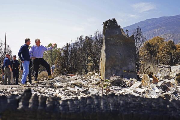California Gov. Gavin Newsom, front left, and Nevada Gov. Steve Sisolak tour homes destroyed by wildfires near where the Tamarack Fire ignited earlier in July in Gardnerville, Nev., Wednesday, July 28, 2021. The governors of California and Nevada are calling for increased federal assistance as they tour an area blackened by one of several massive wildfires that have destroyed dozens of homes. Wednesday's tour of the Tamarack Fire along the state line comes as numerous wildfires char land and homes in a dozen states. (AP Photo/Sam Metz)
