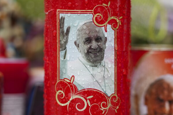 A candle for Pope Francis is seen in front of the Agostino Gemelli Polyclinic, in Rome, Wednesday, March 12, 2025, where the pontiff is hospitalized since Friday, Feb. 14. (AP Photo/Andrew Medichini)