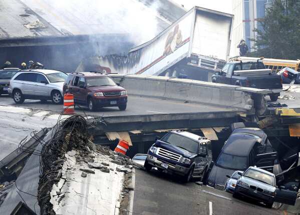 FILE - In this Wednesday, Aug. 1, 2007 picture, vehicles are scattered along the broken remains of the Interstate 35W bridge, which stretches between Minneapolis and St. Paul, after it collapsed into the Mississippi River during evening rush hour. (Stacy Bengs/The Minnesota Daily via AP)