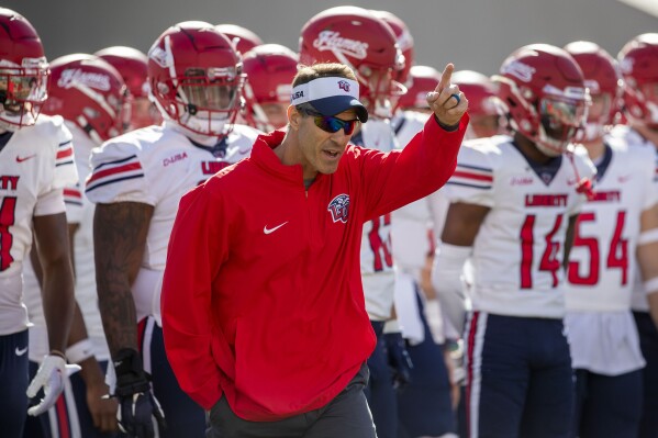 Liberty coach Jamey Chadwell leads his team onto the field to face UTEP in an NCAA college football game on Saturday, Nov. 25, 2023, in El Paso, Texas. Liberty became the first Division I team from Virginia to win 12 games in a season. (AP Photo/Andres Leighton)