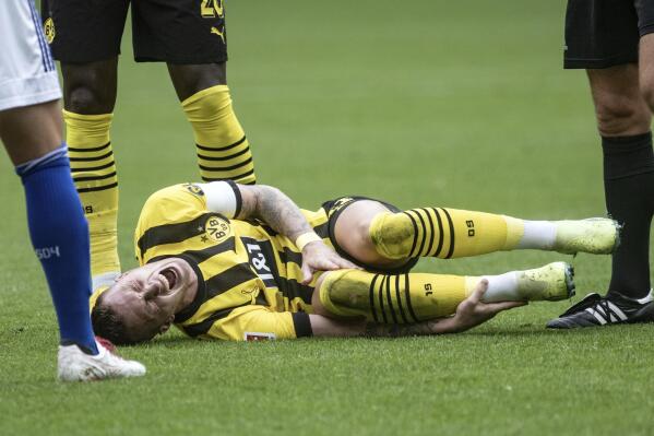 Dortmund's Marco Reus is injured on the ground during the German Bundesliga soccer match between Borussia Dortmund and FC Schalke 04 in Dortmund, Germany, Saturday, Sept. 19, 2022. (Bernd Thissen/dpa via AP)