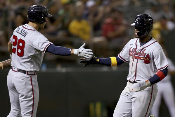 Atlanta Braves' Ronald Acuna Jr., right, is congratulated by Matt Olson (28) after scoring on a sacrifice fly by Austin Riley against the Oakland Athletics during the sixth inning of a baseball game in Oakland, Calif., Tuesday, Sept. 6, 2022. (AP Photo/Jed Jacobsohn)