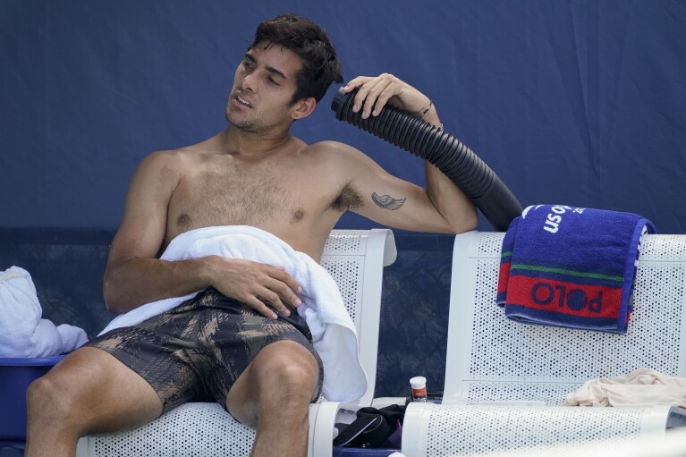 Cristian Garin, of Chile, cools off during a break between games against Norbert Gombos, of Slovakia, during the first round of the US Open tennis championships, Aug. 30, 2021, in New York. (AP Photo/John Minchillo, File)