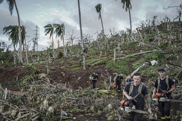 This photo provided by the French Interior Ministry shows rescue workers making their way in a devastated area of the French territory of Mayotte in the Indian Ocean, after the island was battered by its worst cyclone in nearly a century, Tuesday Dec. 17, 2024. (Ministere de l'Interieur/Securite Civile via AP)