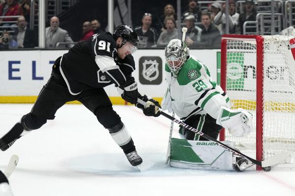 Los Angeles Kings right wing Carl Grundstrom, left, tires to get a shot past Dallas Stars goaltender Jake Oettinger during the second period of an NHL hockey game Tuesday, Jan. 3, 2023, in Los Angeles. (AP Photo/Mark J. Terrill)