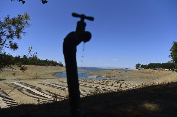 CORRECTS YEAR TO 2021 INSTEAD OF 2022 - FILE - Water drips from a faucet near boat docks sitting on dry land at the Browns Ravine Cove area of drought-stricken Folsom Lake in Folsom, Calif., on May 22, 2021. The American West's megadrought deepened so much last year that it is now the driest it has been in at least 1200 years and a worst-case scenario playing out live, a new study finds. (AP Photo/Josh Edelson, File)