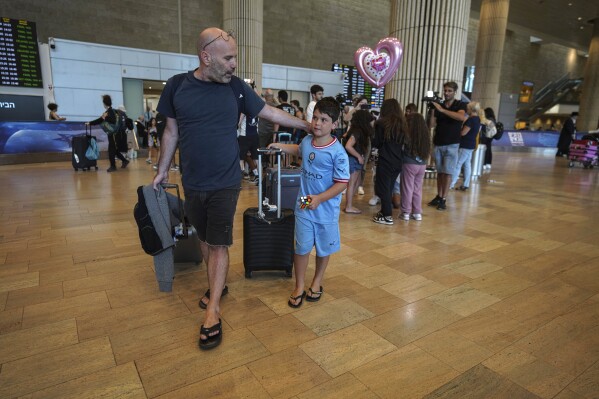 Passengers arriving from the Indian Ocean island nation of Seychelles that made an emergency stop in Saudi Arabia react upon landing at Ben Gurion Airport in Lod, near Tel Aviv, Israel, Tuesday, Aug. 29, 2023. Israeli media reported the Air Seychelles flight carrying 128 passengers was forced to land Monday because of an electrical malfunction. Israel's Foreign Ministry said the passengers spent the night at an airport hotel in Jeddah and were flown back by the airline on an alternate plane. (AP Photo/Tsafrir Abayov)