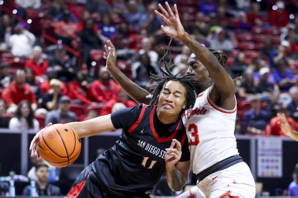 San Diego State guard Jazlen Green (11) drives against UNLV center Desi-Rae Young (23) during the first half of an NCAA college basketball game for the championship of the Mountain West women's tournament Wednesday, March 13, 2024, in Las Vegas. (AP Photo/Ian Maule)