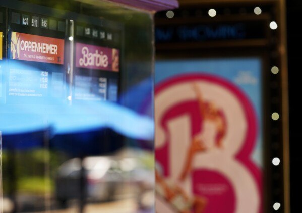 Showtimes for the films "Oppenheimer" and "Barbie" are pictured behind the ticket booth at the Los Feliz Theatre, Friday, July 28, 2023, in Los Angeles. (AP Photo/Chris Pizzello)