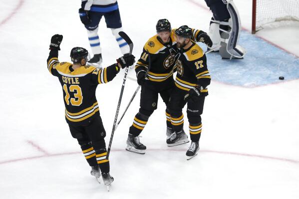 Boston Bruins left wing Nick Foligno (17) is congratulated for his goal against the Winnipeg Jets by Trent Frederic (11) and Charlie Coyle (13) during the third period of an NHL hockey game Thursday, Dec. 22, 2022, in Boston. (AP Photo/Mary Schwalm)