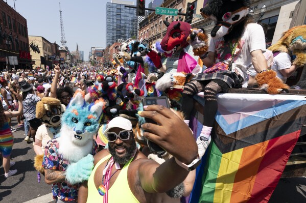 Derrick McKissack takes a selfie with the Murfreesfurs during the Nashville Pride Parade Saturday, June 24, 2023, in Nashville, Tenn. (AP Photo/George Walker IV)