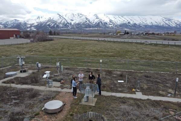 Climate Data Analyst Casey Olson, center left, of Utah State University stands with students during a tour of the climate reference station on April 1, 2024, in Logan, Utah. Increasingly, U.S. universities are creating climate change programs to meet demand from students who want to apply their firsthand experience to what they do after high school. (AP Photo/Rick Bowmer)