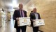 FILE - Steve Bakken, left, and Casey Neumann, of the New Economic Frontier ballot initiative group, carry boxes containing petitions to the Secretary of State's Office on Monday, July 8, 2024, at the state Capitol in Bismarck, N.D. (AP Photo/Jack Dura, File)