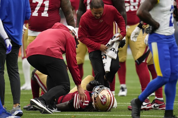 San Francisco 49ers wide receiver Brandon Aiyuk is checked on after being injured during the first half of an NFL football game against the Los Angeles Rams Sunday, Sept. 17, 2023, in Inglewood, Calif. (AP Photo/Gregory Bull)