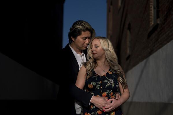 Jessica Tincopa and her husband, Rob Tran, stand for a portrait in Orange, Calif., Friday, May 5, 2023. Tincopa may leave the photography business she spent 14 years building for one reason: to find coverage for fertility treatment. After six miscarriages, Tincopa and her husband started saving for in vitro fertilization, which can cost well over $20,000, but the pandemic wiped out their savings and the state's health insurance marketplace doesn't cover things like IVF. (AP Photo/Jae C. Hong)