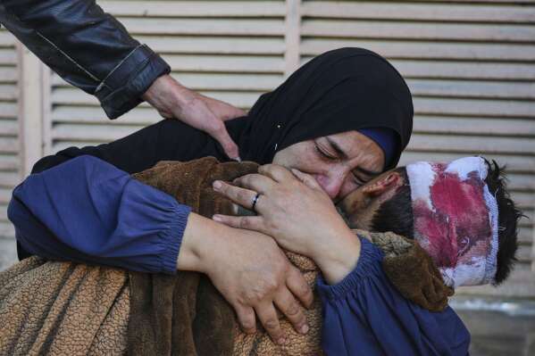 Palestinian Maha Elayan weeps as she embraces the body of her 7-year-old son, Qasim, who was killed in an overnight Israeli airstrike on a UN school used as a shelter, ahead of his burial at Al-Aqsa Hospital in Deir al-Balah, in the central Gaza Strip, May 7, 2025. (AP Photo/Abdel Kareem Hana)