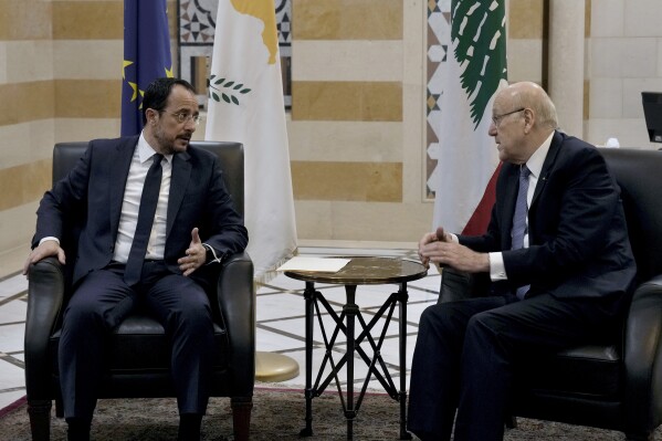Cyprus' President Nikos Christodoulides, left, meets with Lebanese caretaker Prime Minister Najib Mikati at the government headquarters in Beirut, Lebanon, Monday, April 8, 2024. Christodoulides' visit to Beirut comes after he asked the European Union last week to intervene with Lebanese authorities to stop boatloads of Syrian refugees from heading to the east Mediterranean island nation. Lebanon's caretaker prime minister asked Southern European countries along the Mediterranean Sea to pressure the European Union to help Lebanon deport undocumented migrants. (AP Photo/Bilal Hussein)