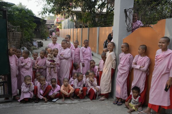 Buddhist nuns watch a processional parade as part of a celebration of a novitiation or “Shinbyu,” ceremony, Saturday, March 15, 2025, at Hlegu township, outside of Yangon, Myanmar. (AP Photo/Thein Zaw)