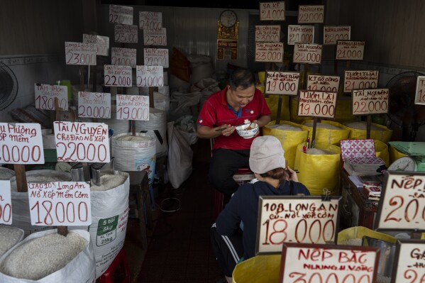 Rice shop owner Vo Tan Nha and his wife eat bowls of rice for lunch in their shop in Ho Chi Minh City, Vietnam, Tuesday, Jan. 30, 2024. Rice isn't just the mainstay of most meals, it is considered a gift from the gods and continues to be venerated. (AP Photo/Jae C. Hong)