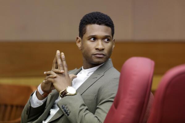 R&B singer Usher waits for a child custody hearing to begin, Friday, Aug. 9, 2013, in Atlanta. A judge in Atlanta is set to hear arguments in the child custody battle between Usher and his ex-wife. Tameka Foster Raymond requested the hearing earlier this week after the former couple's son got caught in a pool drain while in the care of Usher's aunt. (AP Photo/David Goldman)