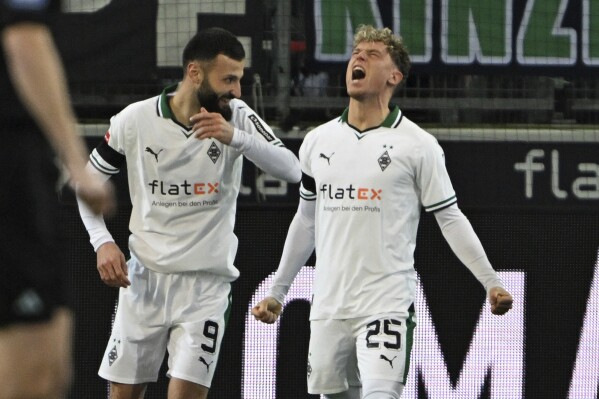 Monchengladbach's Robin Hack, right, celebrates scoring with Franck Honorat during the Bundesliga soccer match between Borussia Monchengladbach and VfB Stuttgart in Monchengladbach, Germany, Sunday Jan. 14, 2024. (Federico Gambarini/dpa via AP)