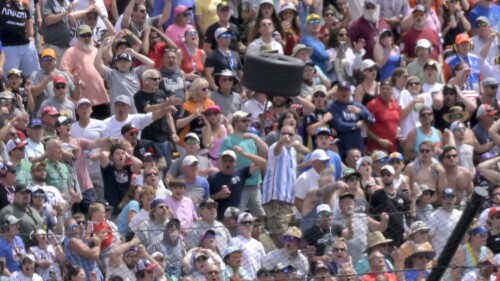 FILE - A wheel flies near a section of grandstand in the second turn after a collision between Kyle Kirkwood and Felix Rosenqvist during the 107th running of the Indianapolis 500, Sunday, May 28, 2023, at Indianapolis Motor Speedway in Indianapolis. IndyCar will implement a new, stronger piece of hardware designed to keep rear wheels attached to the car during a wreck after a tire flew off Kyle Kirkwood's car and narrowly missed a packed grandstand during the Indianapolis 500. The series said Wednesday, July 19, that chassis manufacturer Dallara had designed a retaining nut that is more than 60% stronger than the previous design. (Jef I. Richards /The Indianapolis Star via AP, File)