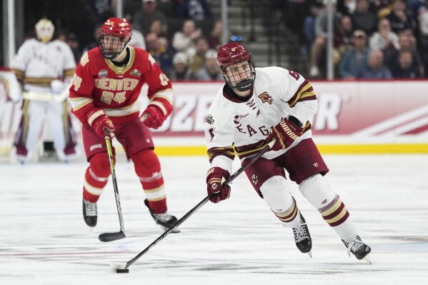 FILE - Boston College forward Will Smith (6) skates down ice with the puck ahead of Denver forward Kieran Cebrian (24) during the third period in the championship game of the Frozen Four NCAA college hockey tournament, April 13, 2024, in St. Paul, Minn. The San Jose Sharks signed prized prospect Smith to a three-year entry-level contract on Tuesday, May 28, after one stellar season at Boston College. (AP Photo/Abbie Parr, File)