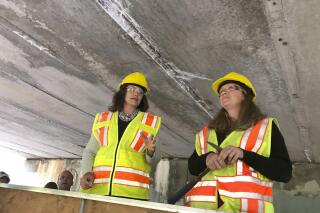 FILE - Michigan Gov. Gretchen Whitmer, left, and Michigan Department of Transportation deputy chief bridge engineer Rebecca Curtis inspect the Elm Street bridge over the Red Cedar River, Monday, Aug. 12, 2019, in Lansing, Mich. Gov. Gretchen Whitmer will propose a $1 billion, or nearly 20%, boost to Michigan's transportation budget to repair roads and increase spending on transit and other programs. The $6.3 billion plan the governor will present to lawmakers Wednesday, Feb. 9, 2022, includes nearly $378 million in new road and bridge funding from the federal infrastructure law. (AP Photo/David Eggert)