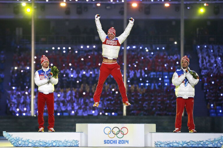 FILE - From left, silver medal winner Maxim Vylegzhanin, gold medal winner Alexander Legkov and bronze medal winner Ilia Chernousov, all of Russia, pose on the podium during the medals ceremony for the men's 50K cross-country race during the closing ceremony of the 2014 Winter Olympics, in Sochi, Russia, on Sunday, Feb. 23, 2014. A subsequent doping scandal tainted the success of the Russian team at the Sochi Games. (AP Photo/Darron Cummings, File)