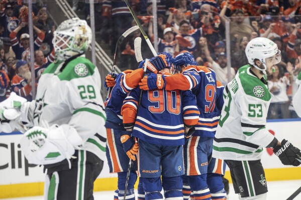 Edmonton Oilers players celebrate a goal as Dallas Stars goalie Jake Oettinger (29) and Wyatt Johnston (53) look on during second period NHL Western Conference final playoff action, in Edmonton on Tuesday, May 27, 2025. (Jason Franson/The Canadian Press via AP)