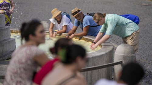 Tourists cool off at a fountain while visiting Rome, Saturday, July 22, 2023. An intense heat wave has hit Italy, bringing temperatures close to 40 degrees Celsius in many cities across the country.  (AP Photo/Andrew Medichini)