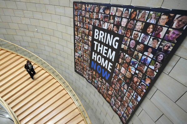 FILE - A banner with photographs of Israeli hostages being held by Hamas militants reading "Bring them back now", is placed in the state parliament of North Rhine-Westphalia in Duesseldorf, Germany on Nov. 8, 2023. (AP Photo/Martin Meissner, File)