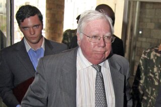 
              FILE - In this Oct. 7, 2008, file photo, Jerome Corsi, right, arrives at the immigration department in Nairobi, Kenya. Corsi, a conservative writer and associate of President Donald Trump confidant Roger Stone says he is in plea talks with special counsel Robert Mueller’s team. Jerome Corsi told The Associated Press on Friday, Nov. 23, 2018, that he has been negotiating a potential plea but declined to comment further. (AP Photo) ** KENYA OUT **
            