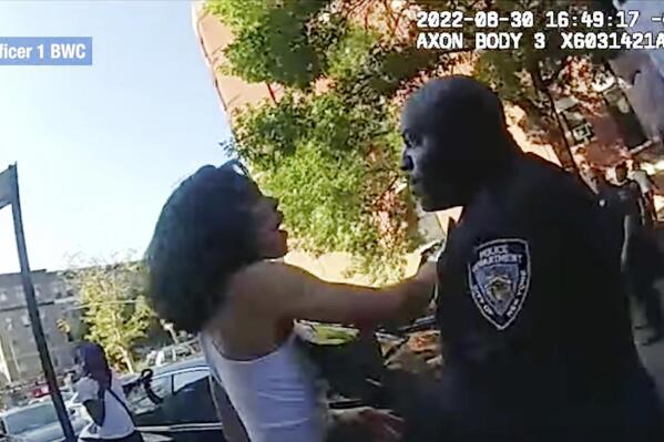 This still image from New York City Police Department body camera video, shows an incident Tuesday, Aug. 30. 2022, in which a detective shoved a woman to the ground after she struck him while he was helping officers arrest an attempted murder suspect in New York's Harlem neighborhood. The woman was one of three people involved in the incident who were arrested for interfering with police and charged with obstructing governmental administration, a misdemeanor. (New York City Police Department via AP)