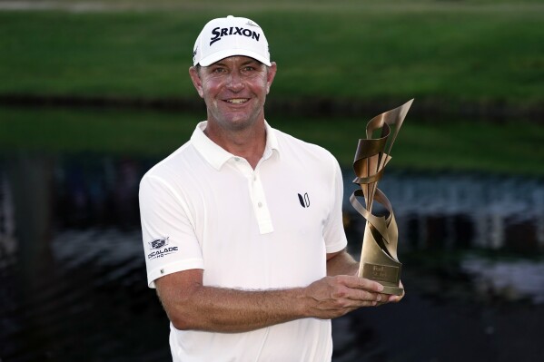 Lucas Glover holds the winner's trophy after winning the St. Jude Championship golf tournament Sunday, Aug. 13, 2023, in Memphis, Tenn. (AP Photo/George Walker IV)