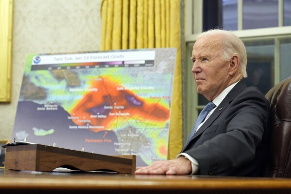President Joe Biden listens during a meeting with senior officials as he is briefed on the federal response to the wildfires across Los Angeles during a meeting in the Oval Office of the Washington, Monday, Jan. 13, 2025. The map in the background show the projected wind speeds. (AP Photo/Susan Walsh)