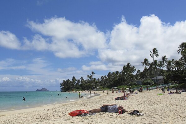 FILE - This Oct. 29, 2013 file photo shows people at Lanikai Beach, a popular neighborhood for vacation rentals, in Kailua, Hawaii. A judge has ruled that Hawaii tax authorities may subpoena Airbnb for records of its hosts as part of an investigation into whether operators of vacation rentals have been paying their taxes. Airbnb says it will hand over records of 1,000 Hawaii hosts who received the most revenue from 2016 through 2018. (AP Photo/Audrey McAvoy, File)