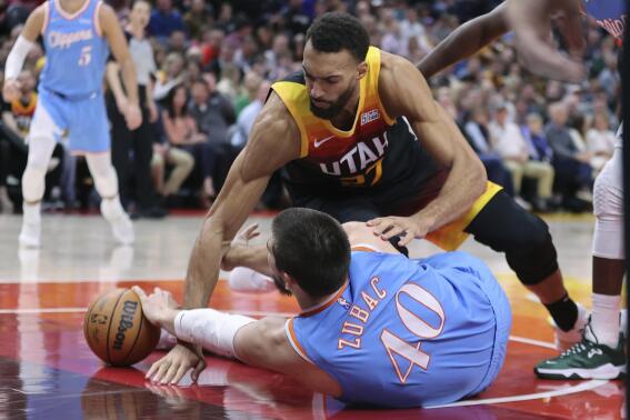 Los Angeles Clippers center Ivica Zubac (40) and Utah Jazz center Rudy Gobert (27) go to the floor for the ball during the second quarter of an NBA basketball game Friday, March 18, 2022, in Salt Lake City. (AP Photo/Rob Gray)