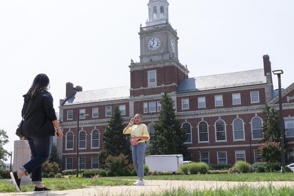 FILE - In this July 6, 2021, file photo with the Founders Library in the background, people walk along the Howard University campus in Washington. With the surprise twin hiring of two of the country's most prominent writers on race, Howard University is positioning itself as one of the primary centers of Black academic thought just as America struggles through a painful crossroads over historic racial injustice. (AP Photo/Jacquelyn Martin, File)