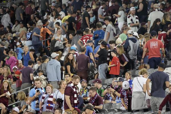 Fans leave their seats as a strong storm packing high winds and heavy rain sweeps over Dick's Sporting Goods Park before the second half of an MLS soccer match between the Colorado Rapids and Minnesota United, Saturday, Aug. 6, 2022, in Commerce City, Colo. (AP Photo/David Zalubowski)