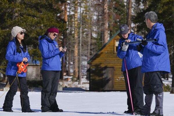 From the California Department of Water Resources, left to right, Angelique Fabbiani-Leon, Manon von Kaenel, Jordan Thoennes and Andy Reising conduct the first snow survey of the season to assess how much water the state might have come spring and summer at Phillips Station on Thursday, Jan. 2, 2025. (AP Photo/Brooke Hess-Homeier)