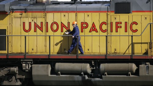 FILE - A maintenance worker walks past the company logo on the side of a locomotive in the Union Pacific Railroad fueling yard in north Denver on Wednesday, Oct. 18, 2006. United Pacific Railroad has reached a tentative deal Sunday, July 9, 2023, with the International Association of Sheet Metal, Air, Rail and Transportation Workers on a paid sick leave agreement. (AP Photo/David Zalubowski, File)