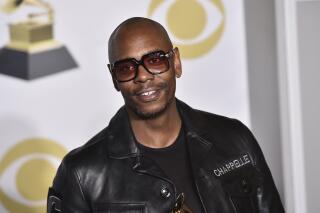 FILE - In this Jan. 28, 2018 file photo, Dave Chappelle poses in the press room with the best comedy album award for "The Age of Spin" and "Deep in the Heart of Texas" at the 60th annual Grammy Awards in New York. Netflix said Friday, Oct. 15, 2021 that it had fired an employee for disclosing confidential financial information about what it paid for Dave Chappelle’s comedy special “The Closer," which some condemned as being transphobic. (Photo by Charles Sykes/Invision/AP, File)