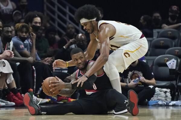 Portland Trail Blazers' Damian Lillard, bottom, looks to pass the ball as Cleveland Cavaliers' Jarrett Allen defends during the first half of an NBA basketball game Wednesday, Nov. 3, 2021, in Cleveland. (AP Photo/Tony Dejak)