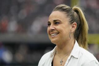 FILE - Las Vegas Aces coach Becky Hammon stands on the field before of an NFL football game between the Denver Broncos and Las Vegas Raiders, Sunday, Oct. 2, 2022 in Las Vegas. The Naismith Memorial Basketball Hall of Fame made it all official on Saturday, April 1, 2023 with three of the NBA’s all-time international greats — Dirk Nowitzki, Tony Parker and Pau Gasol — joining Dwyane Wade, Gregg Popovich and Hammon as the headliners of the 2023 class that will be enshrined on Aug. 11 and 12 at ceremonies in Connecticut and Massachusetts.(AP Photo/Abbie Parr, File)