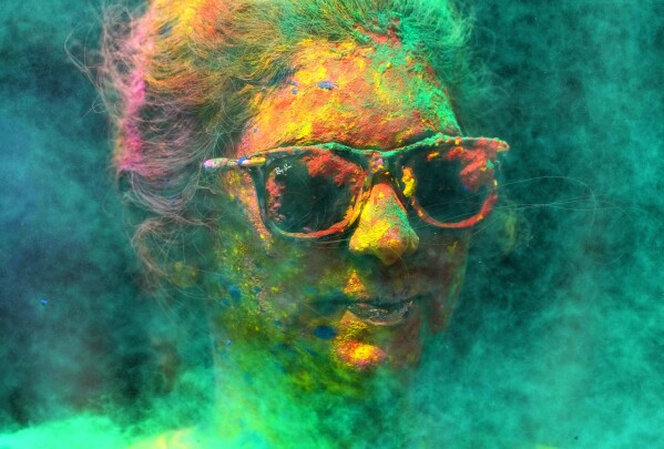 FILE - A woman smeared with colors celebrates Holi, the Hindu festival of colors, in Mumbai, India, Tuesday, March 7, 2023. (AP Photo/Rajanish Kakade, File)